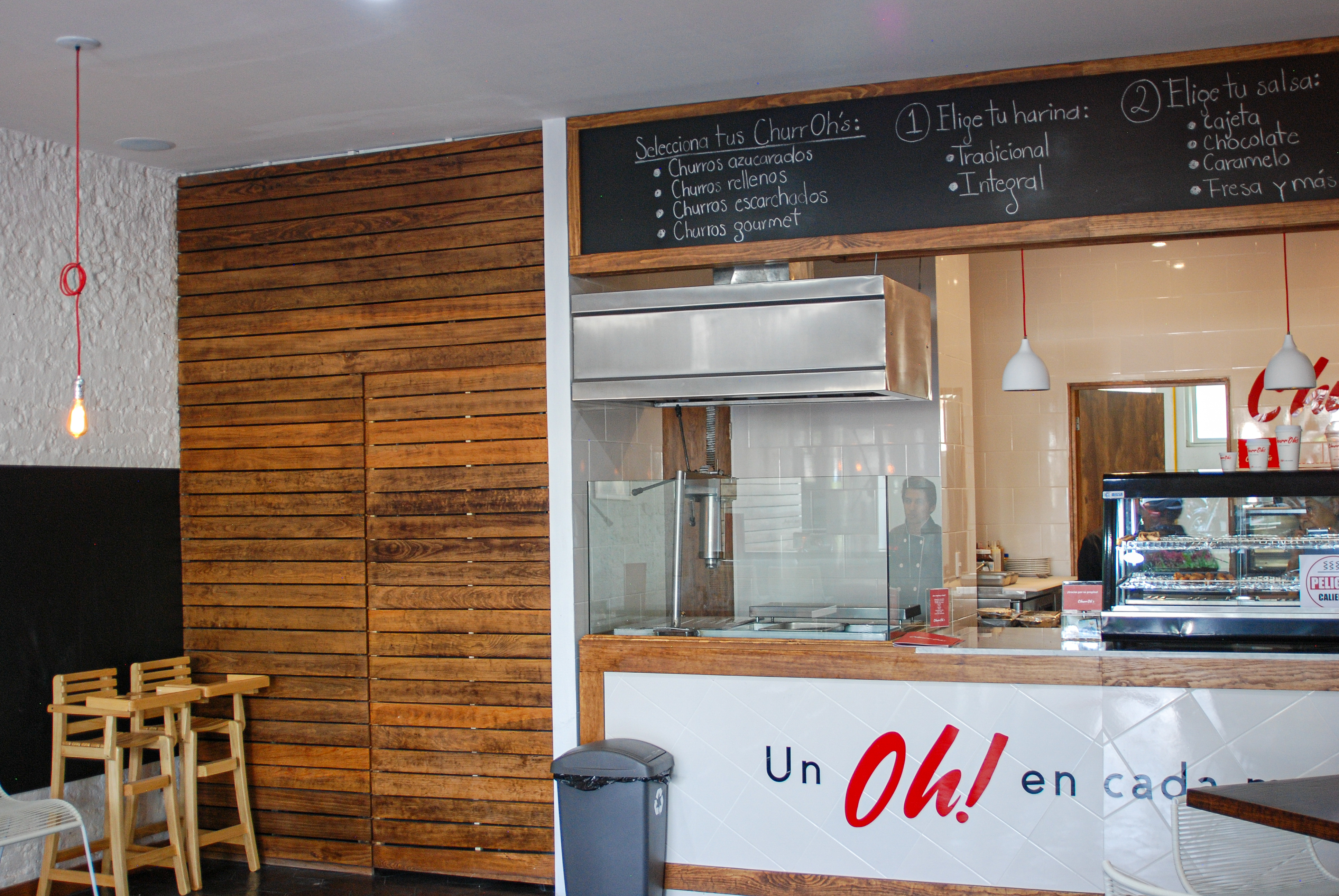 Interior de churrería con barra de trabajo y equipo de cocina, construcción de local comercial Fer Et Ciment León